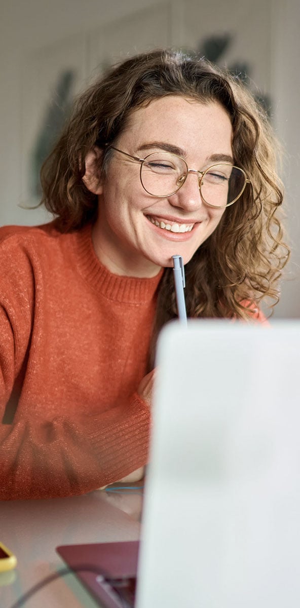 woman smiling while working on laptop