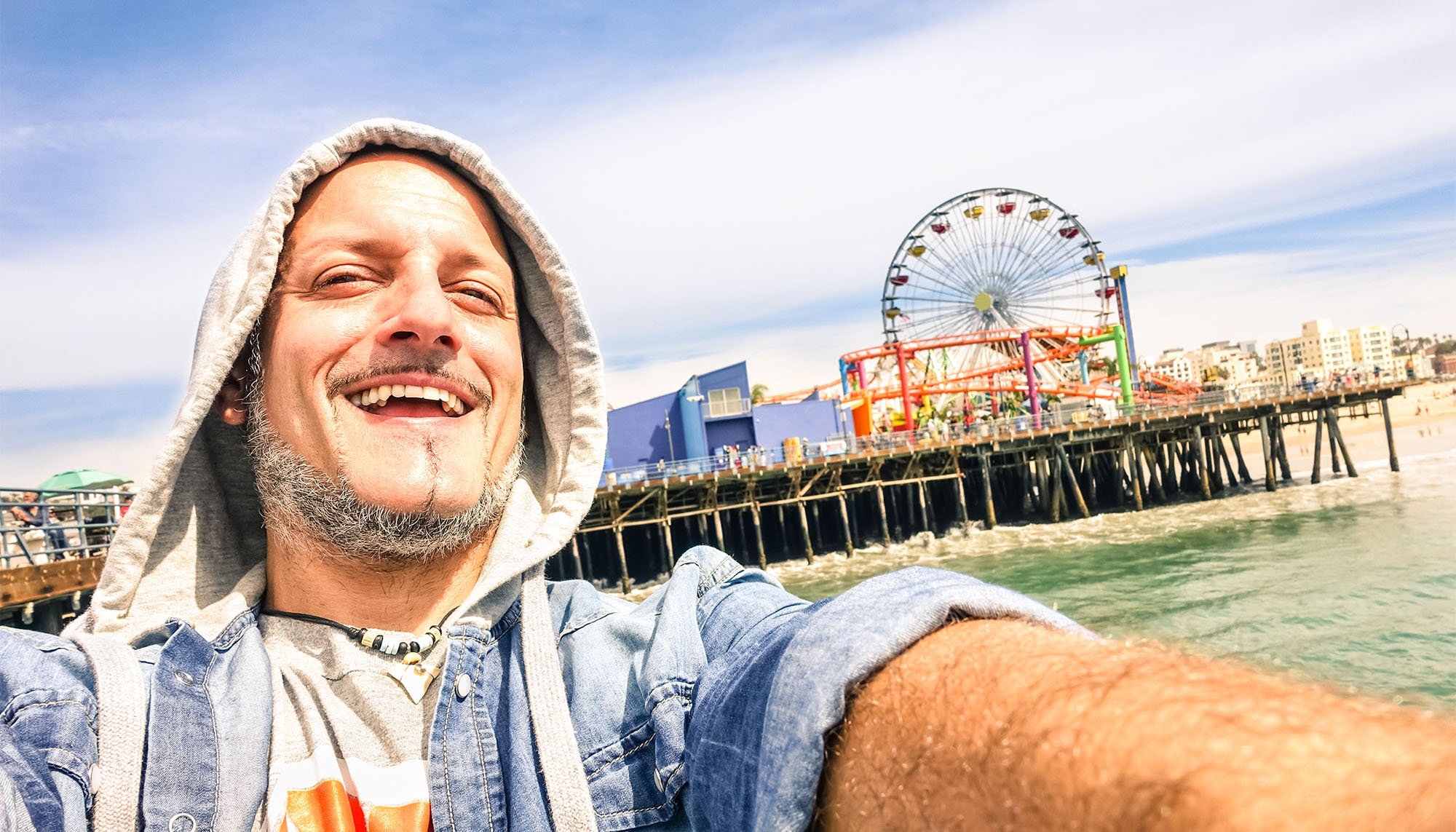 middle aged man taking self with boardwalk in background