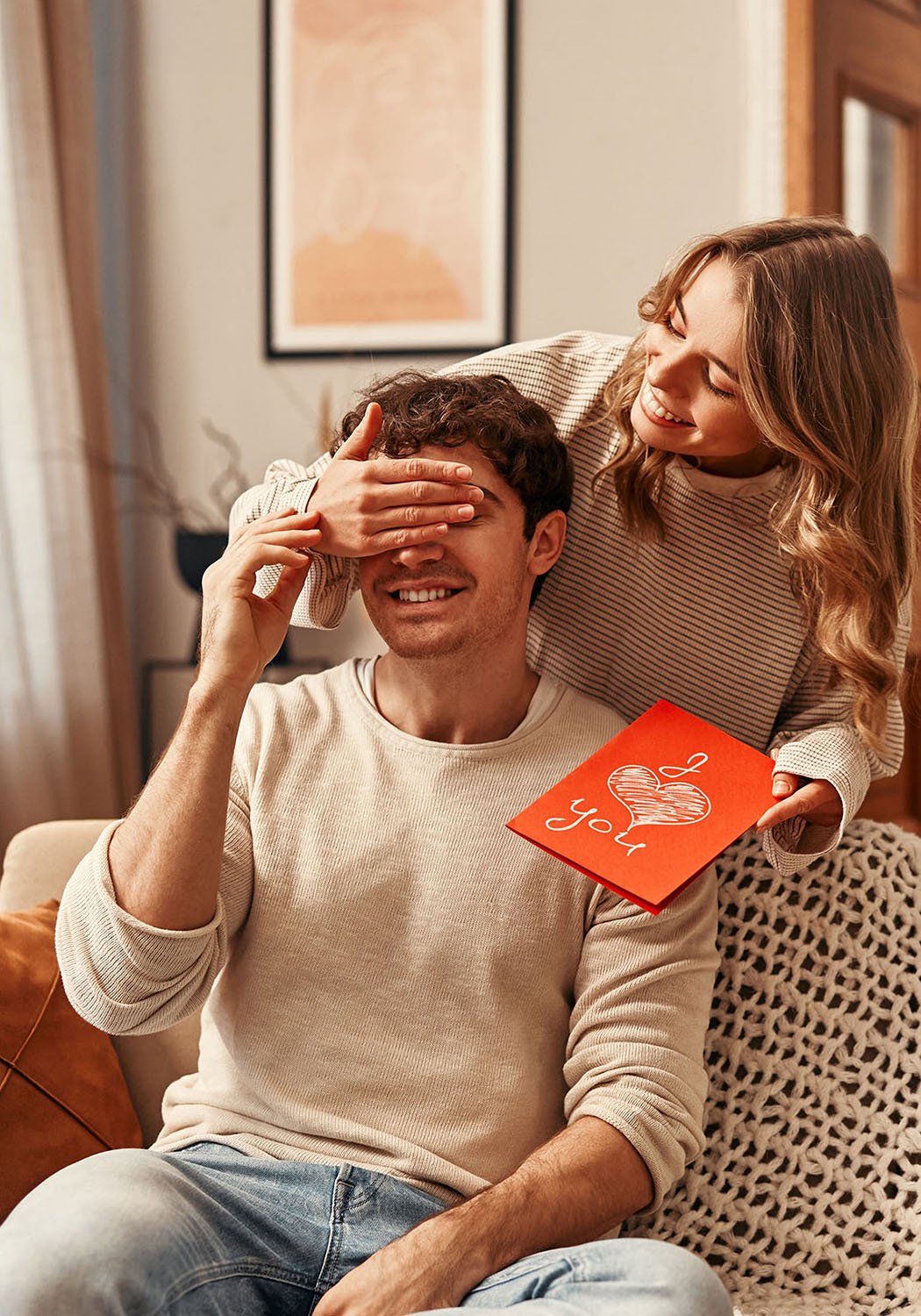 woman suprising man with gift